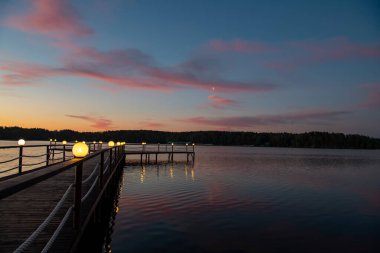 Gün doğumunda nehirde pembe bulutların yansıması