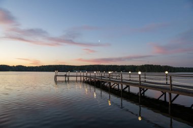 Gün doğumunda nehirde pembe bulutların yansıması