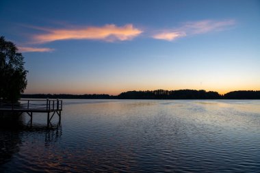 Gün doğumunda nehirde pembe bulutların yansıması