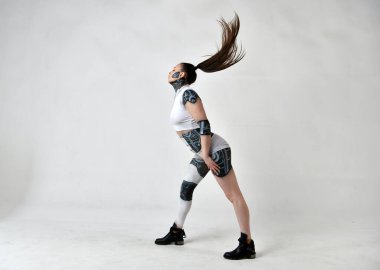 Elbiseli güzel kız saçlarıyla görünüp oynuyor.