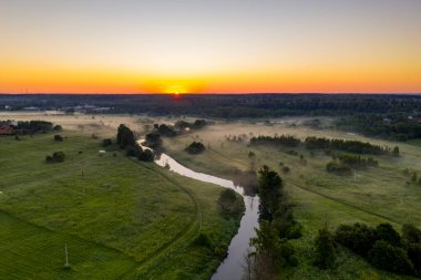 Şafak vakti insansız hava aracından çekilen yeşil tepedeki beyaz taş manastırın panoramik görüntüsü