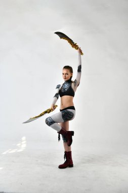 Robot kostümlü güzel kız dövüş sanatları için dövüş kılıçlarıyla egzersiz yapıyor.