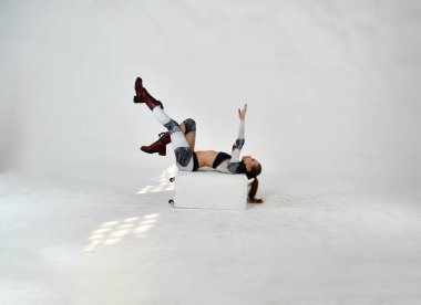 Robot kostümlü güzel kız silahlarla dövüş sanatları için egzersiz yapıyor.