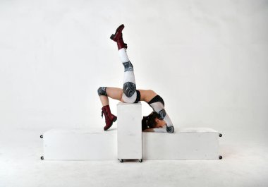 Robot kostümlü güzel bir kız küp üzerinde jimnastik figürler yapıyor.