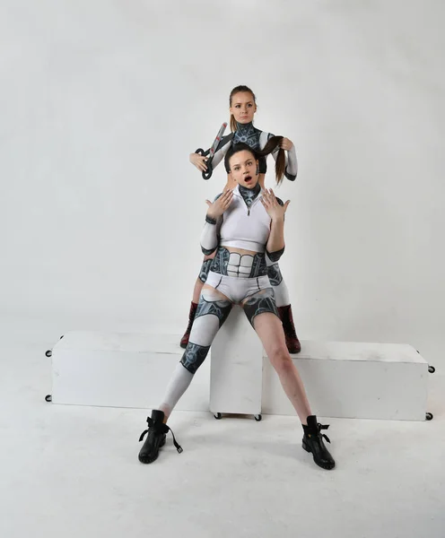 2人の姉妹が世話をするロボットの衣装を着た2人の美しい女の子 — ストック写真