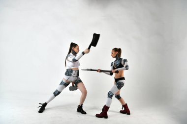 Çocuklar askeri silahlarla savaşırken, robot kostümlü iki güzel kız.