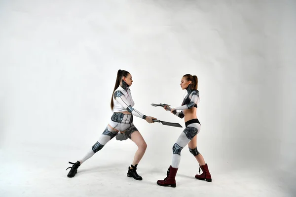 子供の頃ロボットの衣装を着た2人の美しい女の子が軍事兵器と戦い — ストック写真