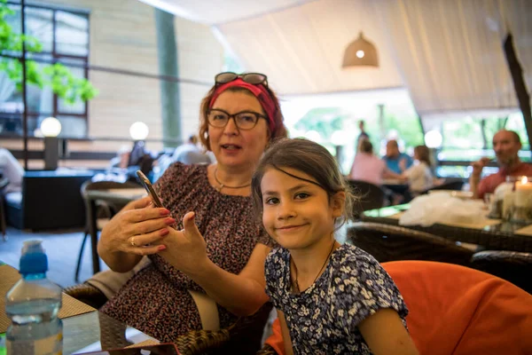 grandmother and granddaughter in a restaurant share their impressions of walks