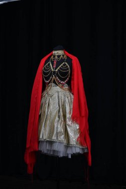 Yüzünde çiçekler olan güzel bir kız ve siyah bir arka planda farklı pozlar veren kestane rengi şakayıklarla resmedilmiş.