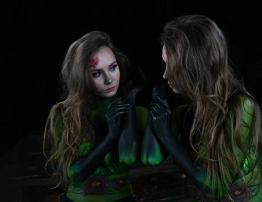 Burgundy şakayıklarıyla boyanmış güzel bir kız ve yansıması siyah bir aynada