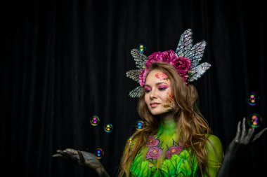 Güzel kız rüyalarında sabun köpüğünün arka planında kırmızı şakayıklarla resmedilmiş.