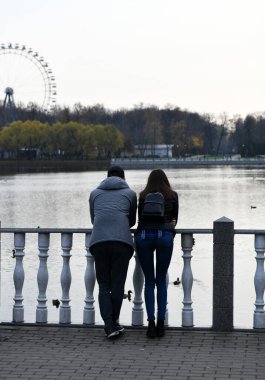 İnsanlar sonbaharda göl kenarında bir gün parkta dinlenirler.