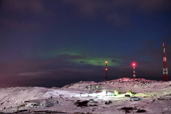 green flashes of the northern lights at night in the arctic are observed from the top of the hill