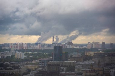 Pencereden yağmur yağdığını görebileceğiniz büyük bir şehir manzarası.