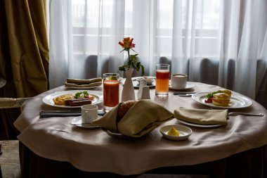 Vazoda iki kişilik bir gülle kahvaltı pencerenin arkasında.