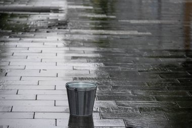 Kaldırımda yağmurda galvanize kova
