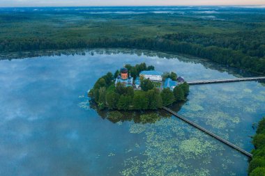 Gün doğumunda gölün ortasındaki antik ada manastırı.