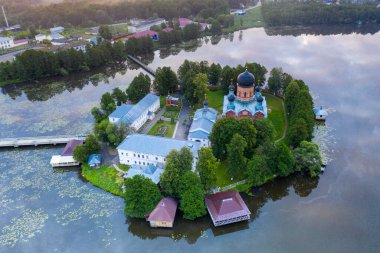 Gün doğumunda gölün ortasındaki antik ada manastırı.