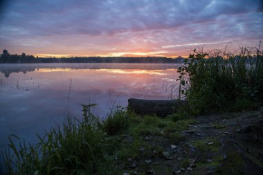 Gün doğumunda gölün ortasındaki antik ada manastırı.