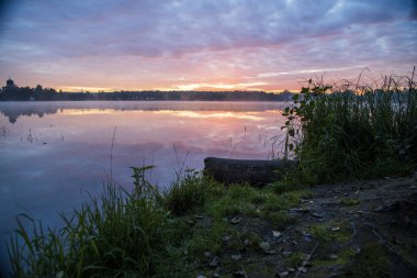 Gün doğumunda gölün ortasındaki antik ada manastırı.