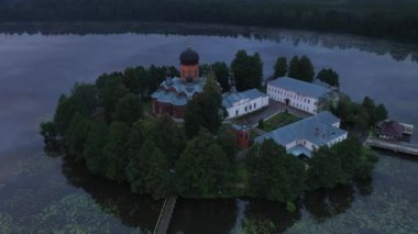 Gün doğumunda gölün ortasındaki antik ada manastırı.