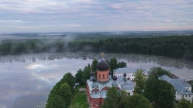 Gün doğumunda gölün ortasındaki antik ada manastırı.