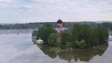 Gün doğumunda gölün ortasındaki antik ada manastırı.