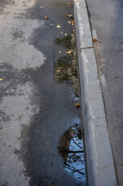 Şehir manzaraları yağmurdan sonra su birikintilerindeki yansımalarla
