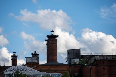 Ortaçağ kalesi olarak kullanılan eski kırmızı tuğla fabrikası bulutlu mavi gökyüzüne karşı.