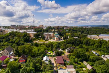 Şehir manzarası eski binalar, yeşil ağaçlar ve bir nehir.