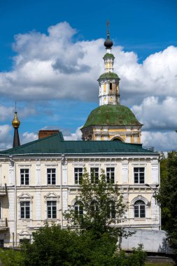 Şehir manzarası eski binalar, yeşil ağaçlar ve bir nehir.