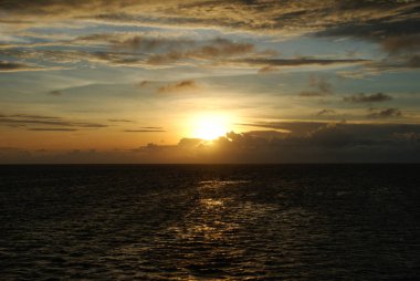 Denizdeki tropikal adalarda gemilerle sihirli gün batımları