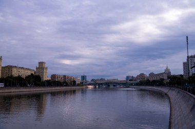 Nehir kıyısında geniş çizgili boruları olan bir fabrika.