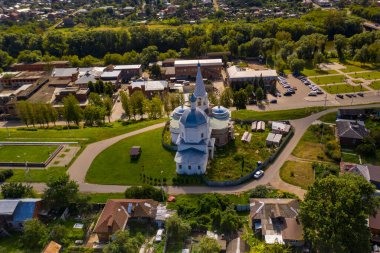 Yazın eski bir kilisenin panoramik manzarası yeşil bir tepede bulutlu bir arka planda