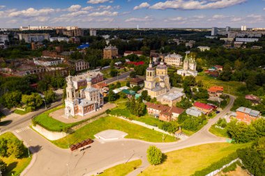 Yazın eski bir kilisenin panoramik manzarası yeşil bir tepede bulutlu bir arka planda