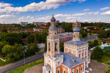 Yazın eski bir kilisenin panoramik manzarası yeşil bir tepede bulutlu bir arka planda
