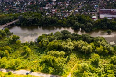 Yazın eski bir kilisenin panoramik manzarası yeşil bir tepede bulutlu bir arka planda