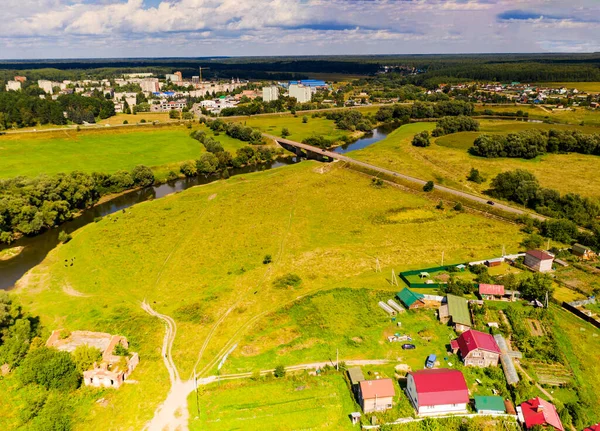 a dark river and green trees in summer aerial view