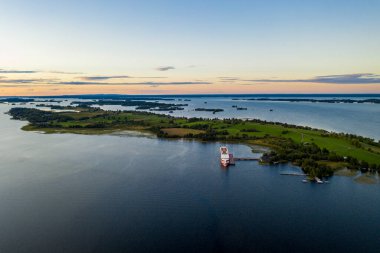 Gölün panoramik manzarası. Birinde bir sürü ada var. Gün batımında ahşaptan yapılmış eski bir tapınak var.