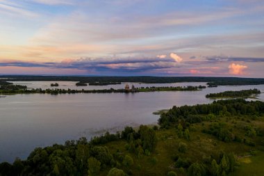 Gölün panoramik manzarası. Birinde ahşaptan yapılmış antik bir tapınak var.