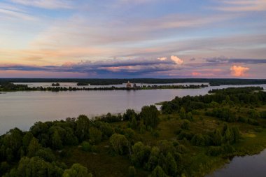 Gölün panoramik manzarası. Birinde ahşaptan yapılmış antik bir tapınak var.