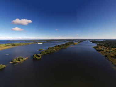 Gölün panoramik manzarası. Birinde ahşaptan yapılmış antik bir tapınak var.