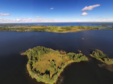 Gölün panoramik manzarası. Birinde ahşaptan yapılmış antik bir tapınak var.