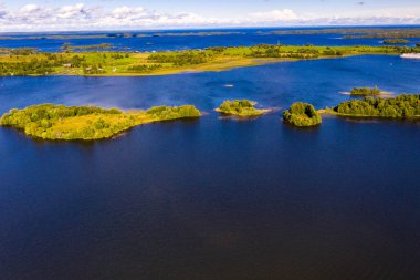 Gölün panoramik manzarası. Birinde ahşaptan yapılmış antik bir tapınak var.