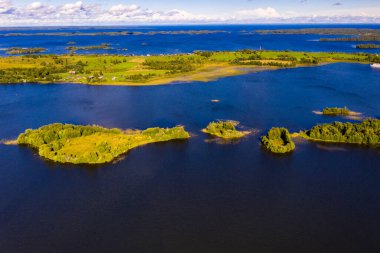 Gölün panoramik manzarası. Birinde ahşaptan yapılmış antik bir tapınak var.
