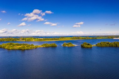 Gölün panoramik manzarası. Birinde ahşaptan yapılmış antik bir tapınak var.