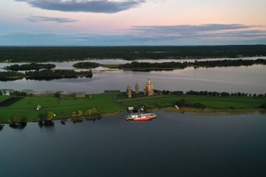 Gölün panoramik manzarası. Birinde ahşaptan yapılmış antik bir tapınak var.