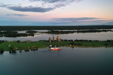 Gölün panoramik manzarası. Birinde ahşaptan yapılmış antik bir tapınak var.