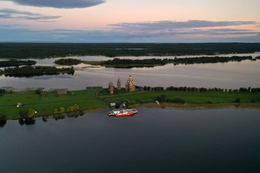 Gölün panoramik manzarası. Birinde ahşaptan yapılmış antik bir tapınak var.
