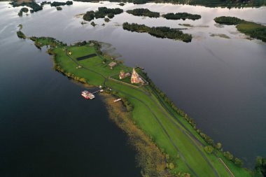 Gölün panoramik manzarası. Birinde ahşaptan yapılmış antik bir tapınak var.